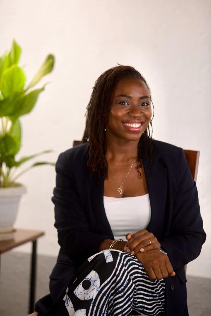 Happie seated in a navy blazer, smiling